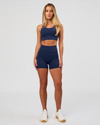 Woman wearing Fusion Ultra High-Rise 4" Short Pockets - Future Navy | Model:Issy | Size:XS