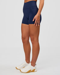 Woman wearing Fusion Ultra High-Rise 4" Short Pockets - Future Navy | Model:Issy | Size:XS