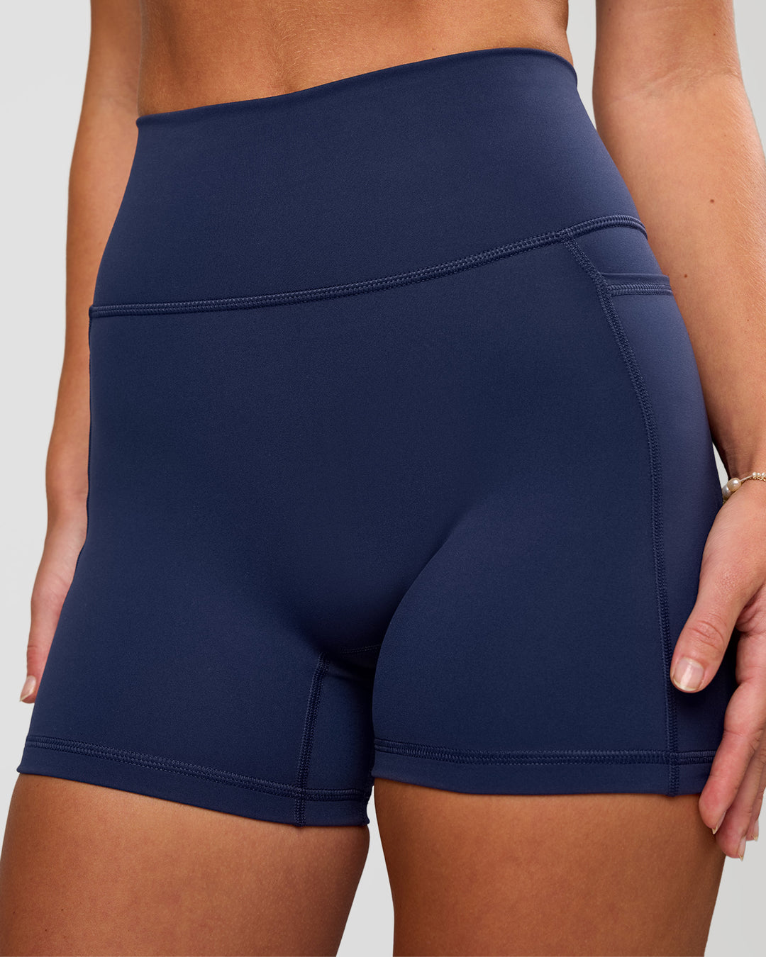 Woman wearing Fusion Ultra High-Rise 4" Short Pockets - Future Navy | Model:Issy | Size:XS