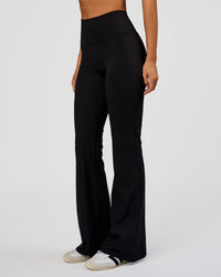 Woman wearing Fusion V-Contour High-Rise Flared Legging Pockets - Black | Model:Charli | Size:XS