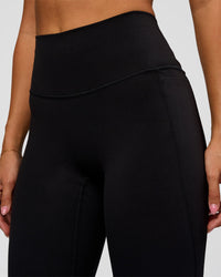 Woman wearing Fusion V-Contour High-Rise Flared Legging Pockets - Black | Model:Charli | Size:XS