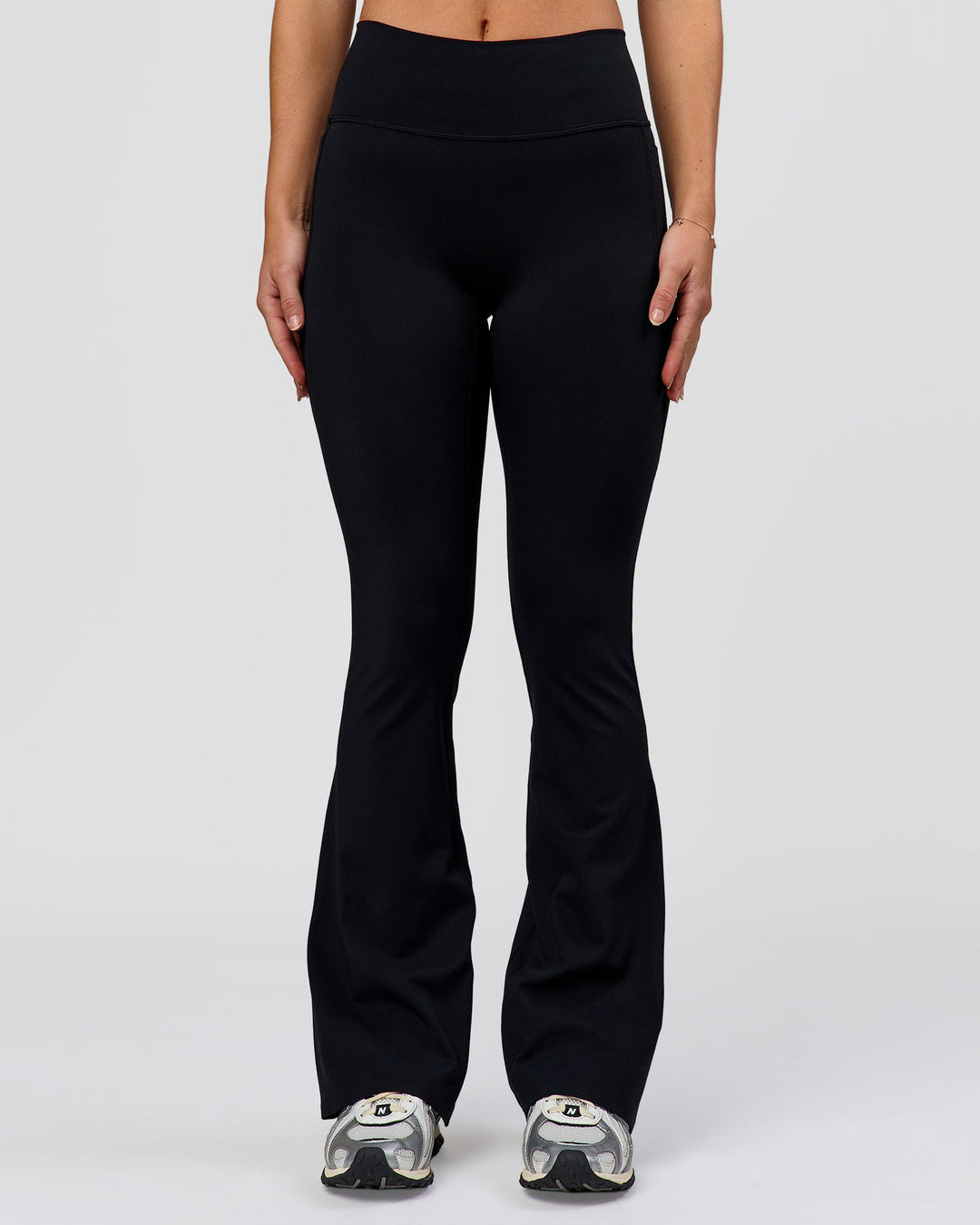 Woman wearing Fusion V-Contour High-Rise Flared Petite Legging Pockets - Black | Model:Issy | Size:XS