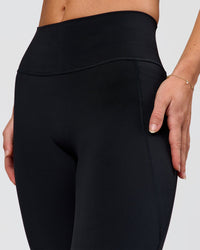 Woman wearing Fusion V-Contour High-Rise Flared Petite Legging Pockets - Black | Model:Issy | Size:XS