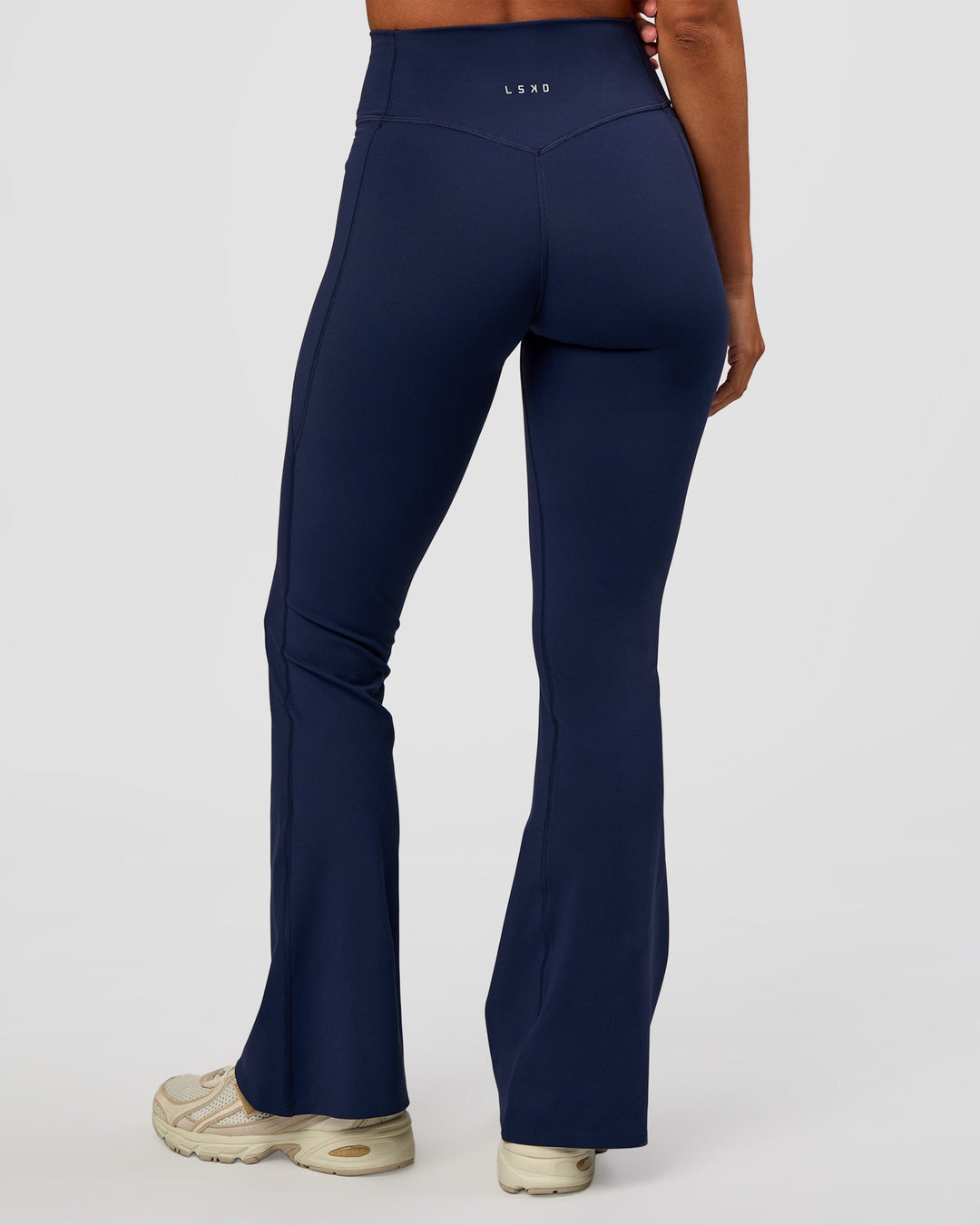 Woman wearing Fusion V-Contour High-Rise Flared Petite Legging Pockets - Future Navy | Model:Brylee | Size:XS