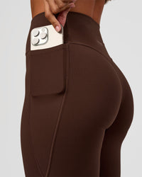 Woman wearing Fusion V-Contour High-Rise Flared Petite Legging Pockets - Hot Chocolate | Model:Brylee | Size:XS