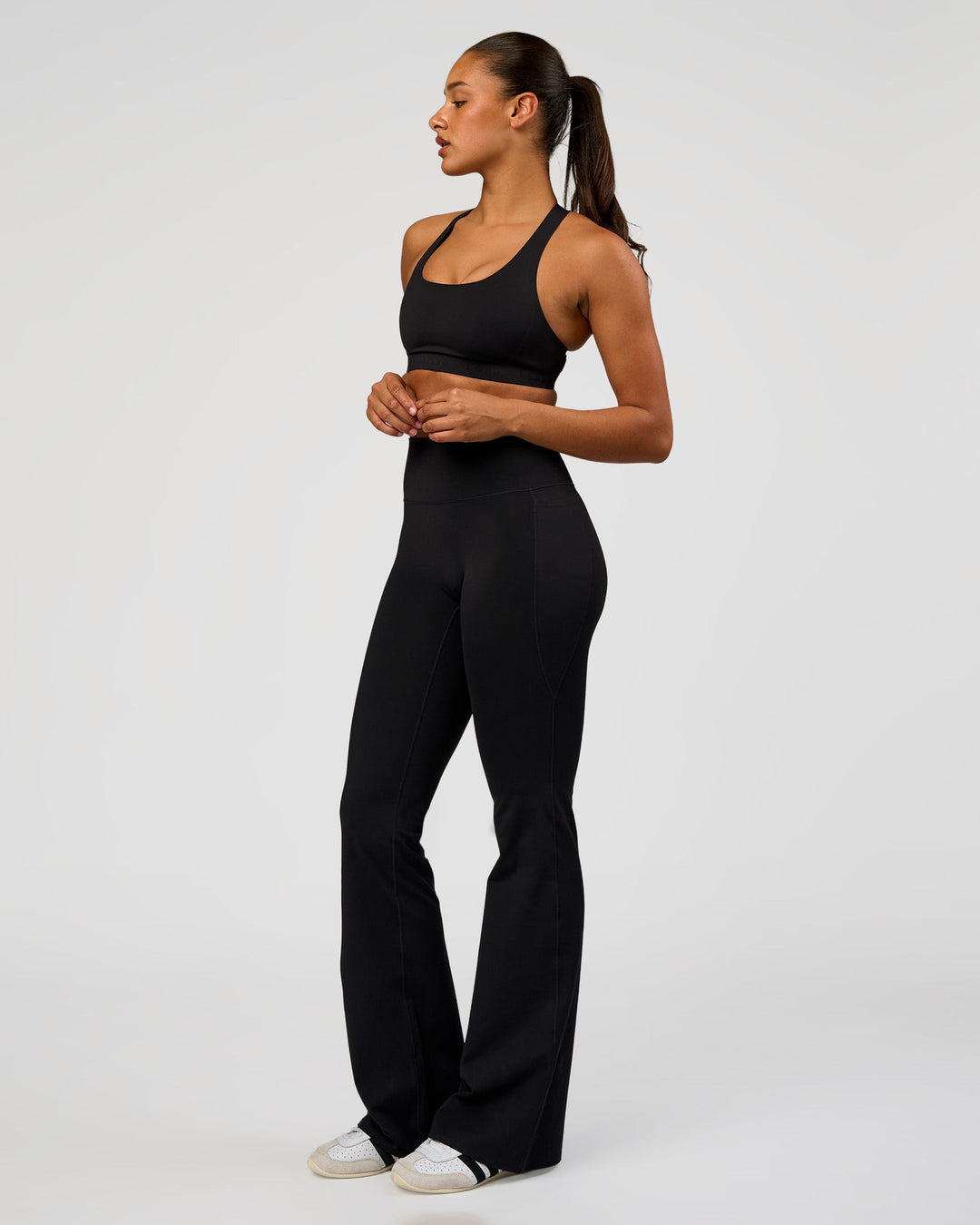 Woman wearing Fusion V-Contour High-Rise Flared Tall Legging Pockets - Black | Model:Rosie | Size:S