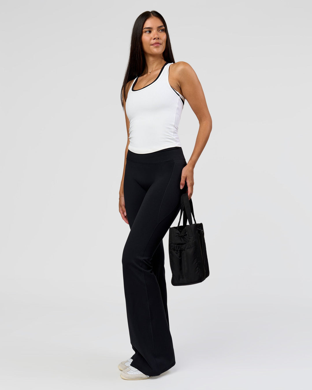 Woman wearing Fusion V-Contour High-Rise Flared Tall Legging Pockets - Black | Model:Rhiley | Size:S