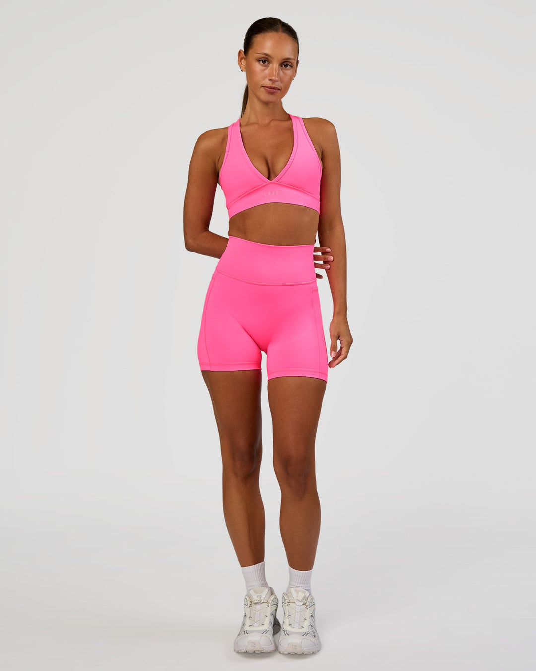 Woman wearing Fusion V-Contour Ultra High-Rise 4” Short Pockets - Sugar Plum | Model:Brylee | Size:XS