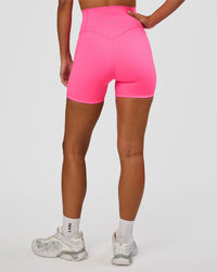 Woman wearing Fusion V-Contour Ultra High-Rise 4” Short Pockets - Sugar Plum | Model:Brylee | Size:XS