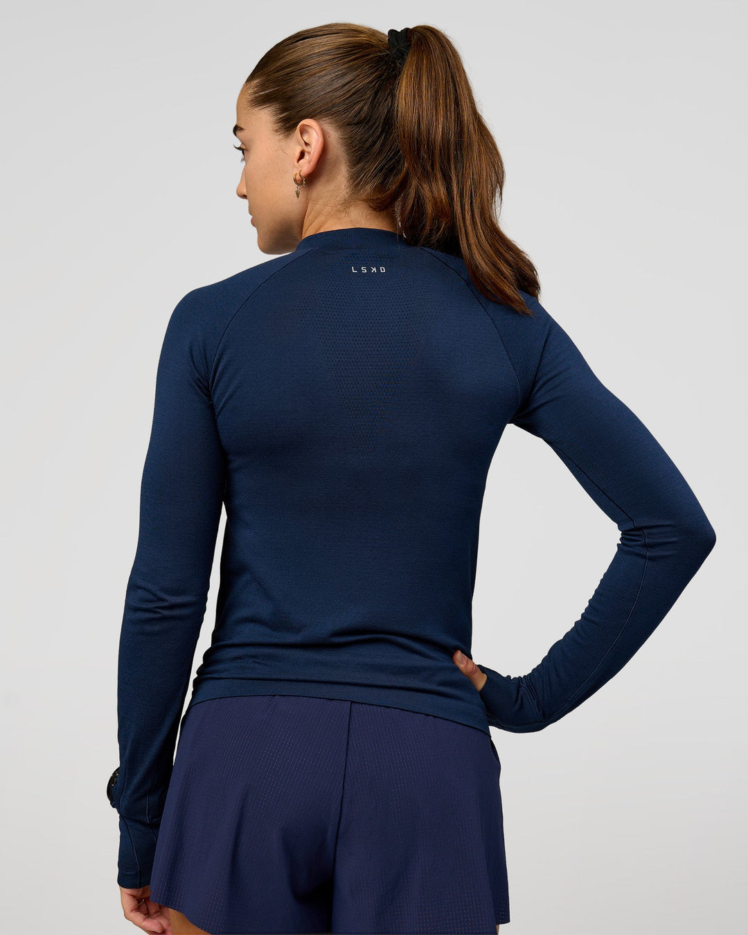Woman wearing GG AeroFLX+ Long Sleeve Half Zip - Future Navy-Baltic Sea | Model:Grace | Size:XS