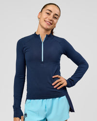 Woman wearing GG AeroFLX+ Long Sleeve Half Zip - Future Navy-Baltic Sea | Model:Grace | Size:XS