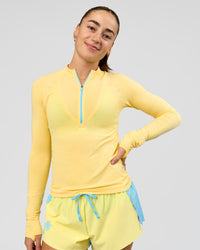 Woman wearing GG AeroFLX+ Long Sleeve Half Zip - Lemon-Baltic Sea | Model:Grace | Size:XS