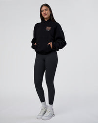 Woman wearing GTC CVC Fleece Unisex Oversized Hoodie - Black-Cantaloupe | Model:Rhiley | Size:XS