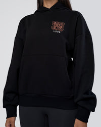 Woman wearing GTC CVC Fleece Unisex Oversized Hoodie - Black-Cantaloupe | Model:Rhiley | Size:XS