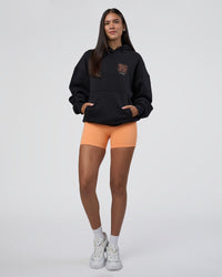Woman wearing GTC CVC Fleece Unisex Oversized Hoodie - Black-Cantaloupe | Model:Rhiley | Size:XS