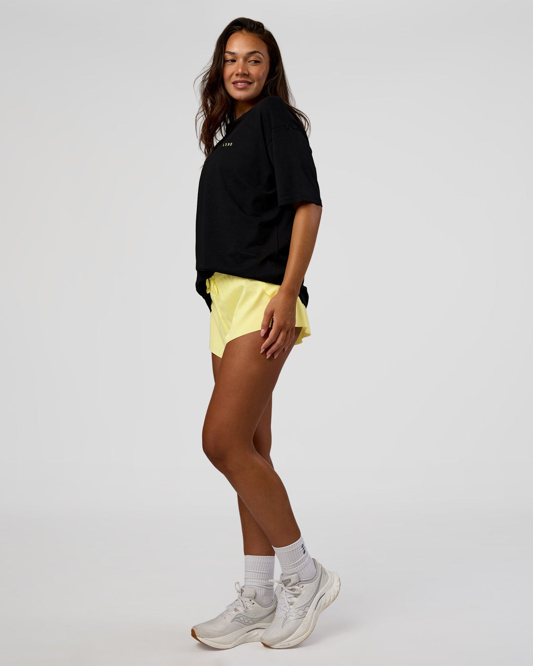 Woman wearing High Run FLXCotton Oversized Tee - Black-Yellow Fizz | Model:Kirstyn | Size:XS