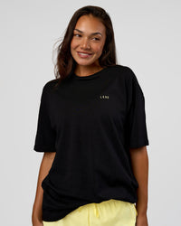 Woman wearing High Run FLXCotton Oversized Tee - Black-Yellow Fizz | Model:Kirstyn | Size:XS
