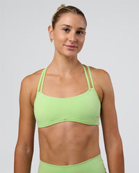 Woman wearing Interstellar Sports Bra - Solar Lime | Model:Emelia | Size:XS