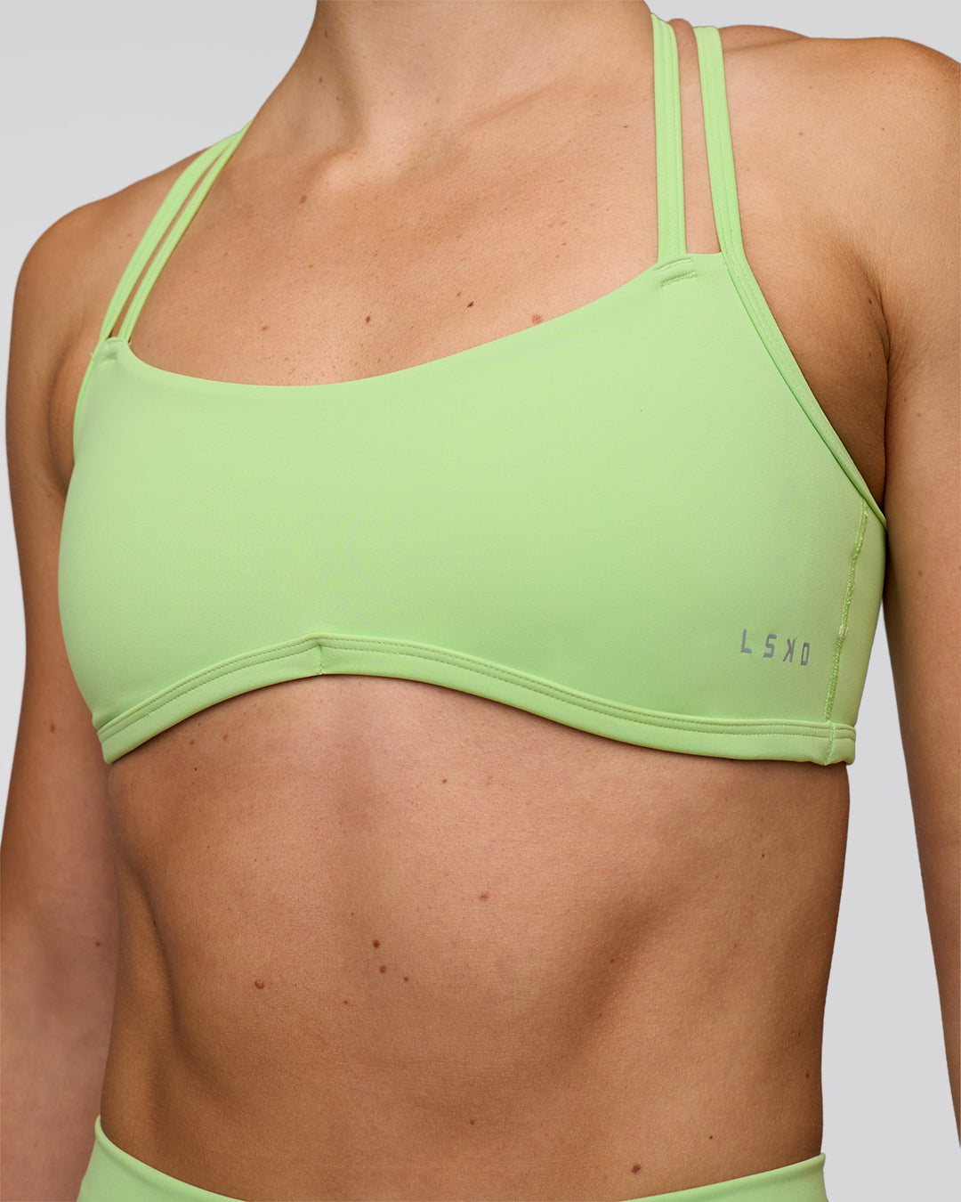 Woman wearing Interstellar Sports Bra - Solar Lime | Model:Emelia | Size:XS