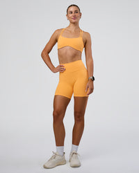 Woman wearing Interstellar Sports Bra - Warm Apricot | Model:Emelia | Size:XS