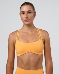 Woman wearing Interstellar Sports Bra - Warm Apricot | Model:Emelia | Size:XS