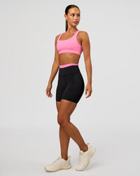 Woman wearing Liberate High-Rise 6" Short Pockets - Black-Candy Pink | Model:Brylee | Size:XS