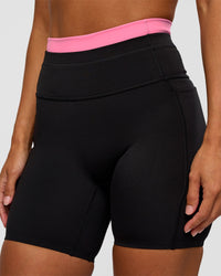 Woman wearing Liberate High-Rise 6" Short Pockets - Black-Candy Pink | Model:Brylee | Size:XS