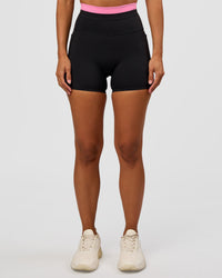Woman wearing Liberate High-Rise 4" Short Pockets - Black-Candy Pink | Model:Brylee | Size:XS
