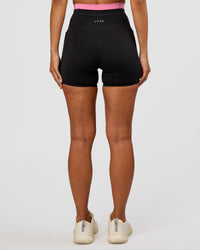 Woman wearing Liberate High-Rise 4" Short Pockets - Black-Candy Pink | Model:Brylee | Size:XS