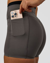 Woman wearing Liberate High-Rise 4" Short Pockets in Duskstone-Black | Model:Maja | Size:XS