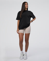 Woman wearing Lifting Club FLXCotton Tee Oversize - Black-Black | Model:Rhiley | Size:XS