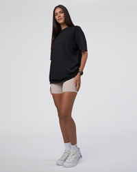 Woman wearing Lifting Club FLXCotton Tee Oversize - Black-Black | Model:Rhiley | Size:XS