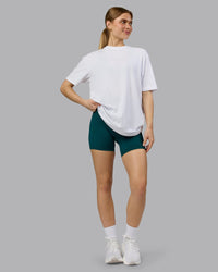 Woman wearing Love The Run FLXCotton Tee Oversize - White-Dark Moss | Model:Emilie | Size:XS