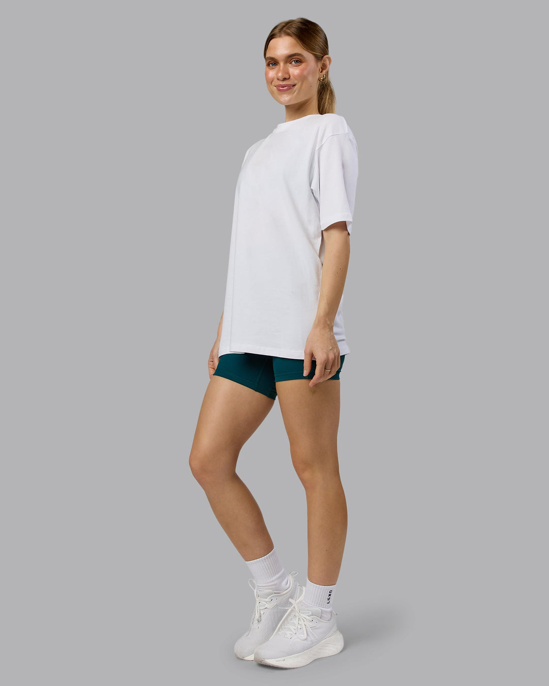 Woman wearing Love The Run FLXCotton Tee Oversize - White-Dark Moss | Model:Emilie | Size:XS