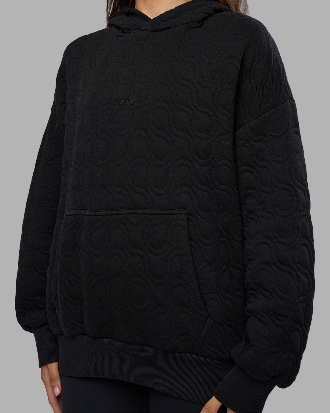 Woman wearing MVP Quilted Oversized Hoodie - Black-Geometric | Model:Phoebe | Size:XS