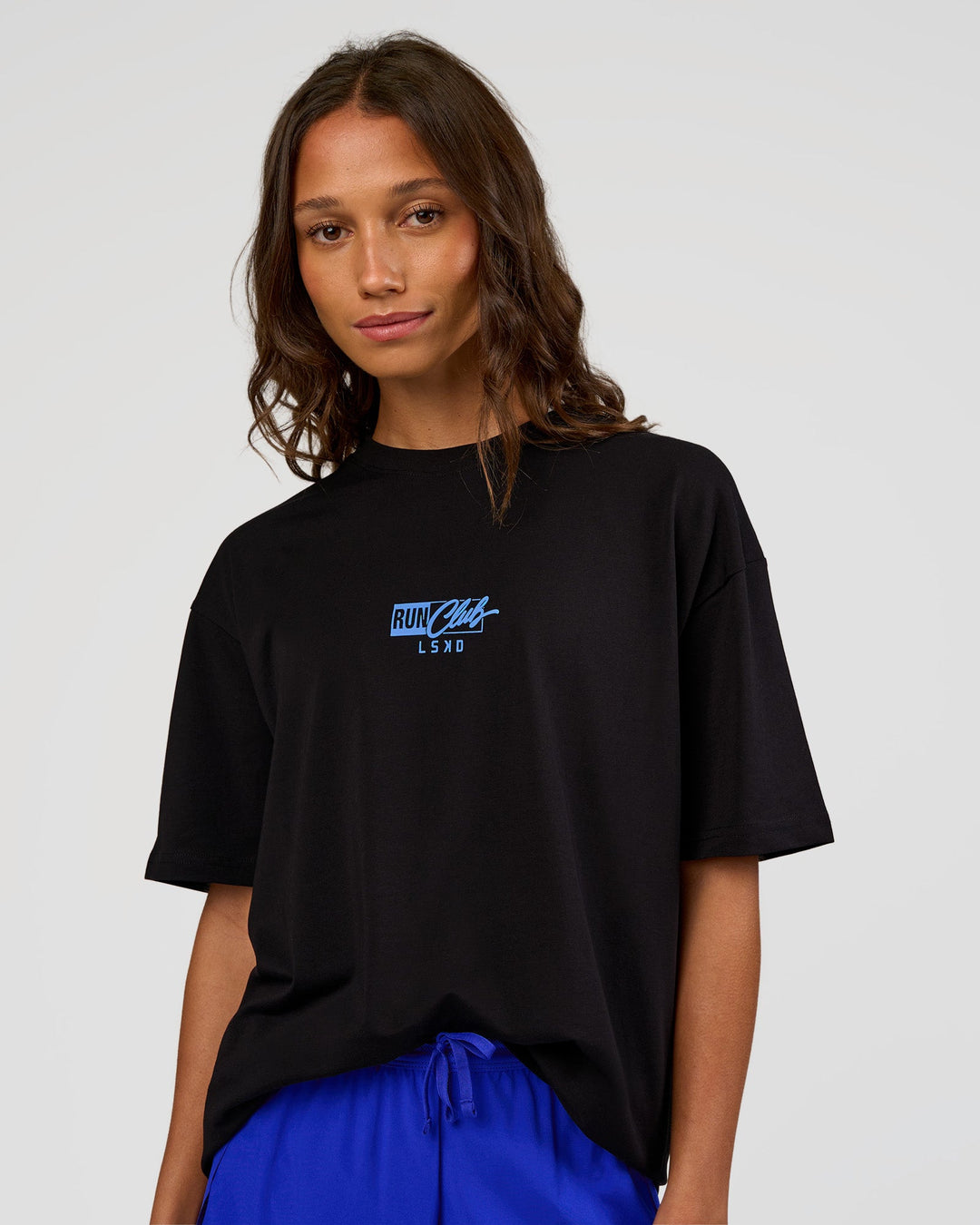 Woman wearing Run Club Script FLXCotton Oversized Tee - Black-Palace Blue | Model:Dakota | Size:XS