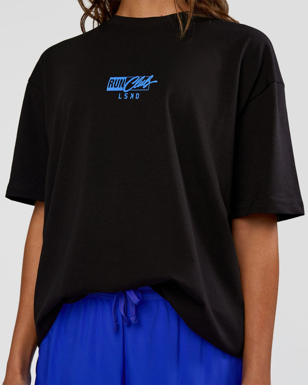 Woman wearing Run Club Script FLXCotton Oversized Tee - Black-Palace Blue | Model:Dakota | Size:XS