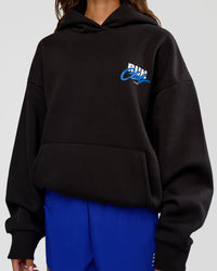 Woman wearing Run Club Script Oversized Hoodie - Black-Palace Blue | Model:Dakota | Size:XS