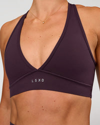 Woman wearing Stamina Sports Bra - Midnight Plum | Set:true | Angle:closeup | Model:Emelia | Size:XS