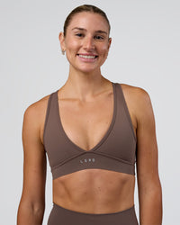 Woman wearing Stamina Sports Bra - Peppercorn | Set:true | Angle:front | Model:Emelia | Size:XS