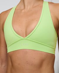 Woman wearing Stamina Sports Bra - Solar Lime | Set:true | Angle:closeup | Model:Emelia | Size:XS