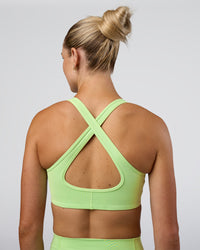 Woman wearing Stamina Sports Bra - Solar Lime | Set:true | Angle:back | Model:Emelia | Size:XS