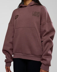 Woman wearing Static Grit Unisex Boxy Hoodie - Cocoa Powder-Hot Chocolate | Model:Loren | Size:XS