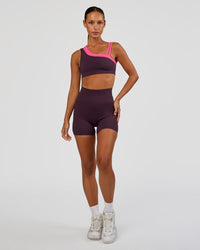Woman wearing Thrive Asymmetric Sports Bra - Midnight Plum-Sugar Plum | Model:Brylee | Size:XS