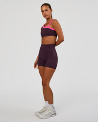Woman wearing Thrive Asymmetric Sports Bra - Midnight Plum-Sugar Plum | Model:Brylee | Size:XS