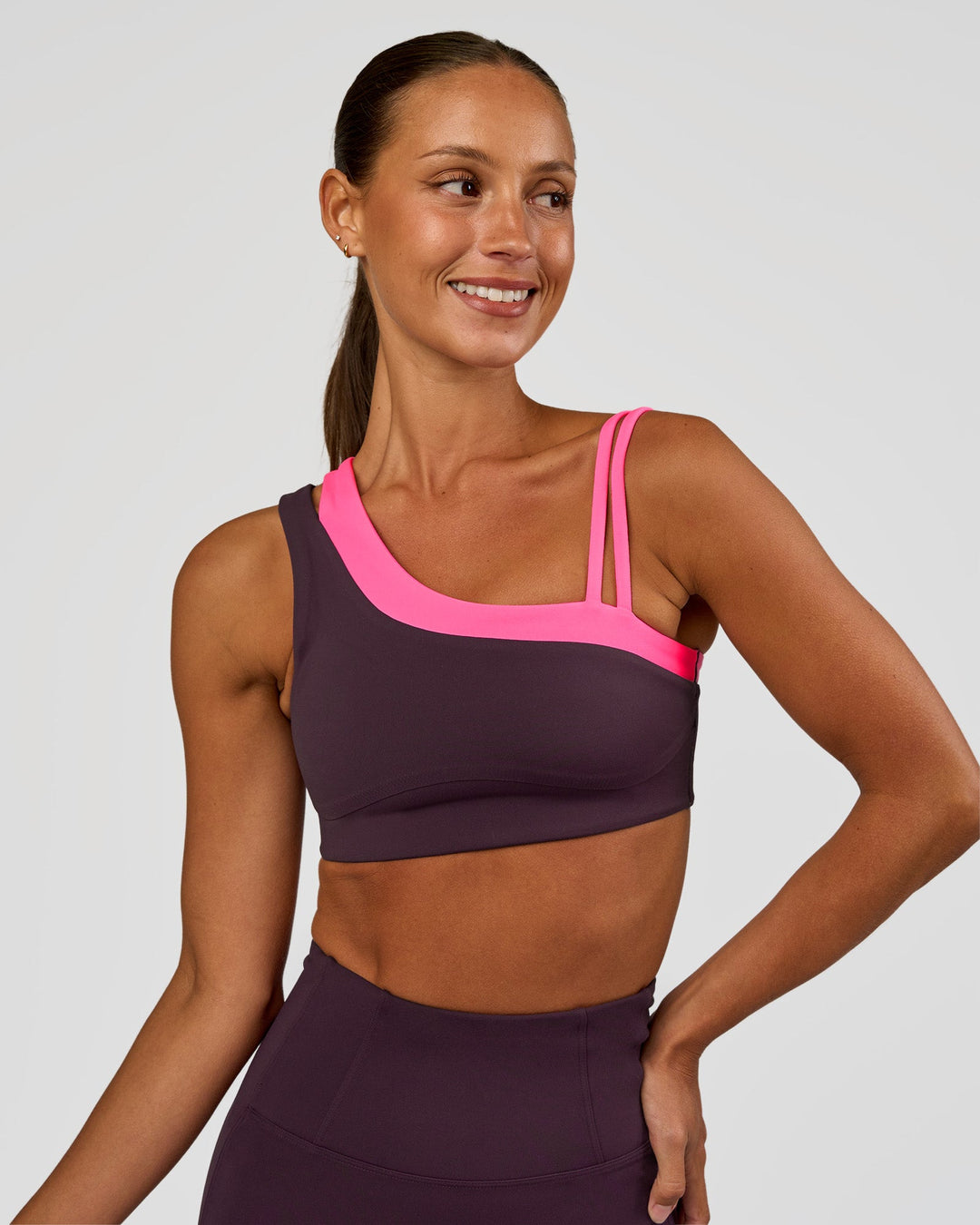 Woman wearing Thrive Asymmetric Sports Bra - Midnight Plum-Sugar Plum | Model:Brylee | Size:XS