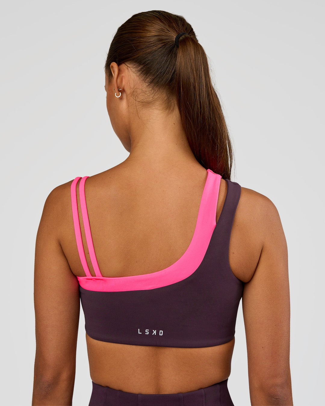 Woman wearing Thrive Asymmetric Sports Bra - Midnight Plum-Sugar Plum | Model:Brylee | Size:XS