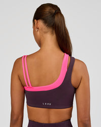 Woman wearing Thrive Asymmetric Sports Bra - Midnight Plum-Sugar Plum | Model:Brylee | Size:XS