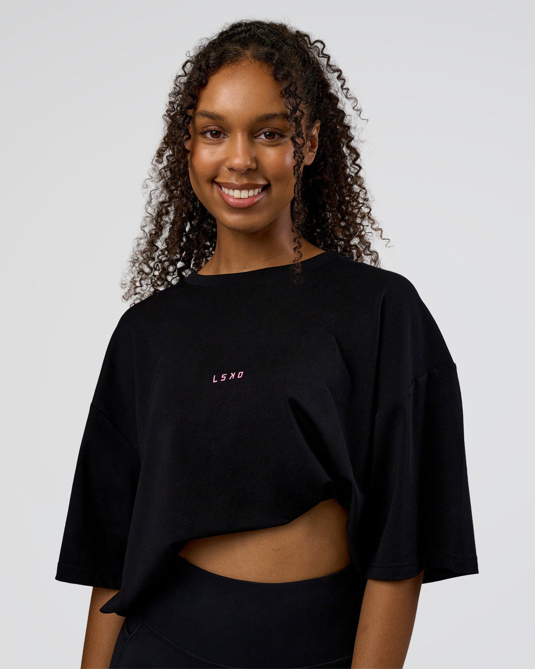 Woman wearing Together We Rise FLXCotton Oversized Tee - Black-Candy Pink | Model:Jordan | Size:XS