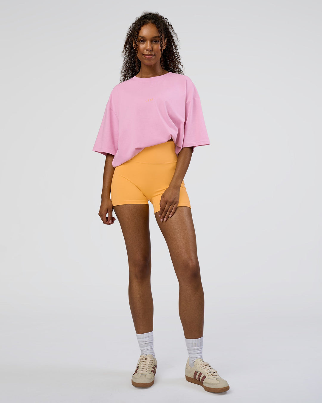 Woman wearing Together We Rise FLXCotton Oversized Tee - Bubblegum-Warm Apricot | Model:Jordan | Size:L